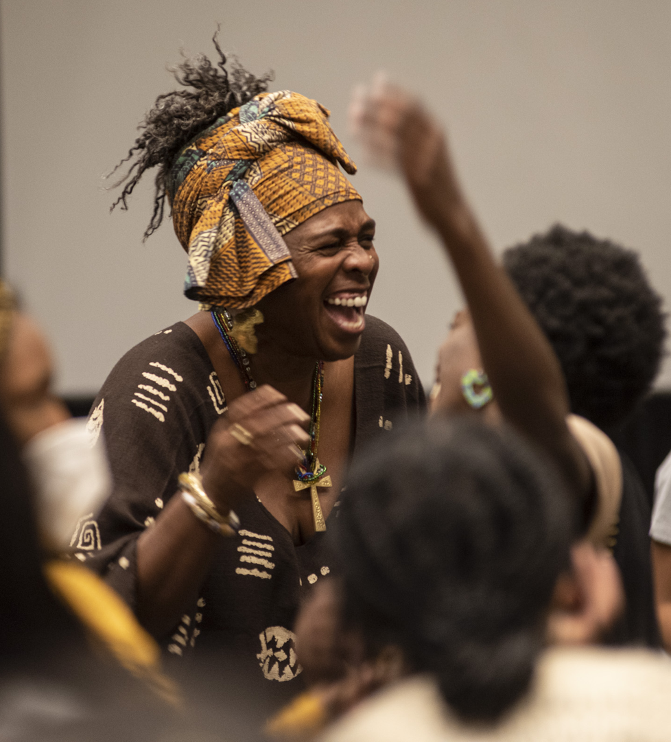 Black woman centered in the middle of a jubilant crowd