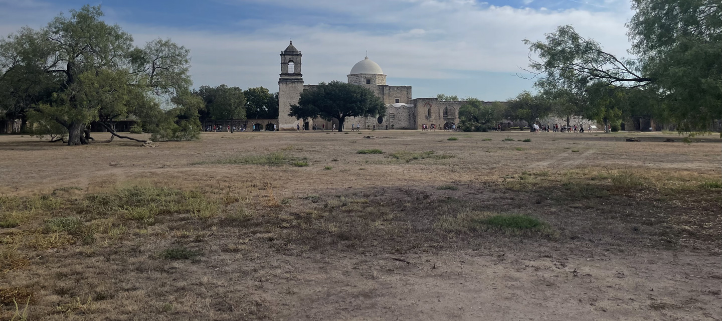 San Antonio Mission with groups of people outside.