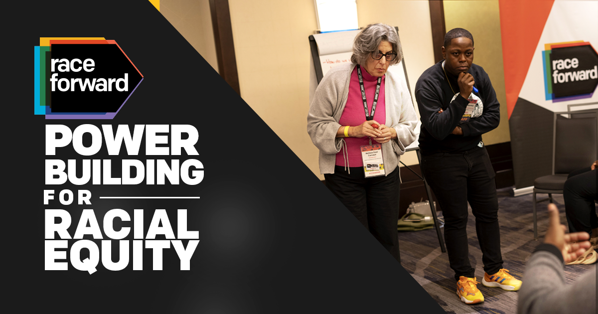 Power Building for Racial Equity. Right-side photo of two Black woman leaning in to listening to an audience member.