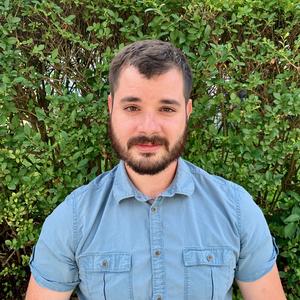 Headshot photo of Daniel Cantrell; white male with short brown hair and full beard, wearing a light blue polo shirt.